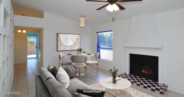 tiled living room with ceiling fan, lofted ceiling, plenty of natural light, and a fireplace