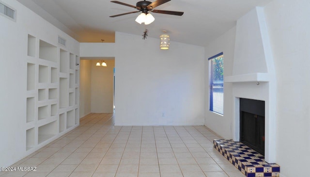 unfurnished living room with built in shelves, ceiling fan, and light tile patterned floors