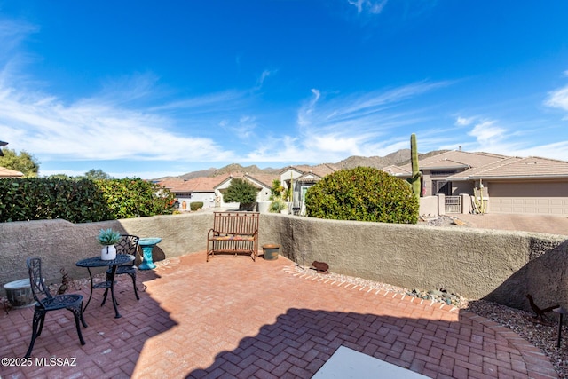 view of patio / terrace with a garage and a mountain view