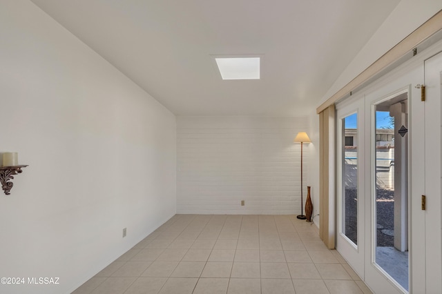 tiled empty room featuring french doors and brick wall