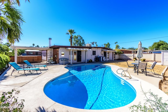 view of swimming pool with a patio, an outbuilding, and a pergola