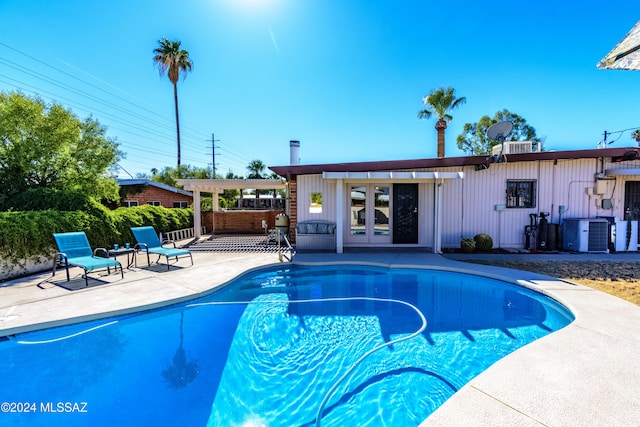 view of swimming pool featuring cooling unit, a pergola, and a patio area