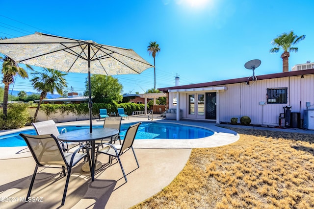 view of pool featuring french doors, an outdoor structure, and a patio