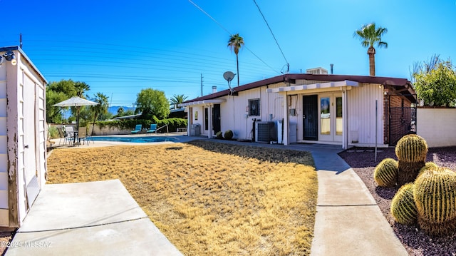 view of front of home with a patio, central air condition unit, and french doors