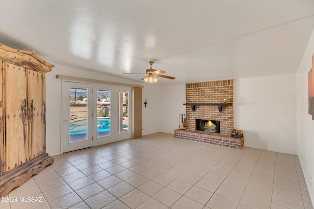 unfurnished living room featuring light tile patterned floors, a fireplace, and brick wall