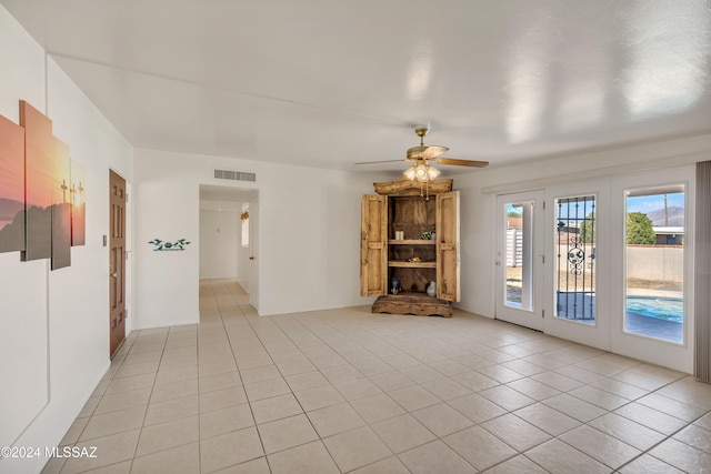 unfurnished living room featuring ceiling fan and light tile patterned floors