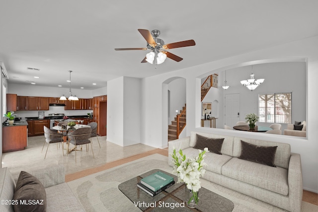 living room with ceiling fan with notable chandelier