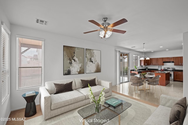 living room featuring ceiling fan and plenty of natural light