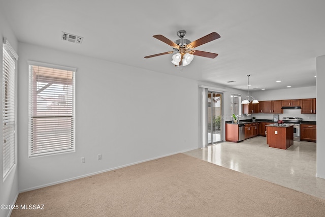 kitchen featuring sink, decorative light fixtures, a center island, ceiling fan, and stainless steel appliances