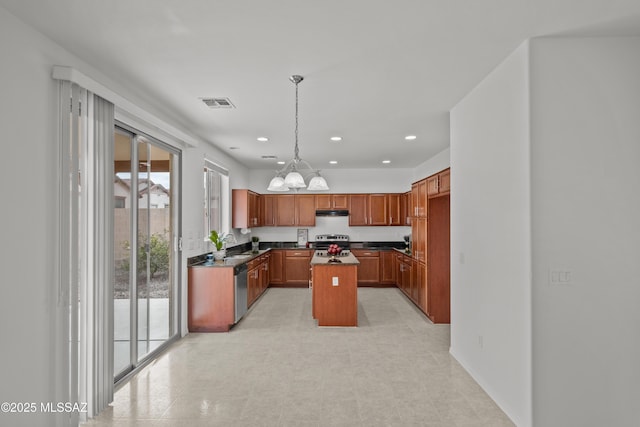 kitchen featuring sink, decorative light fixtures, a chandelier, a center island, and appliances with stainless steel finishes