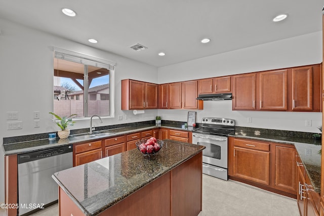 kitchen featuring stainless steel appliances, a kitchen island, sink, and dark stone counters