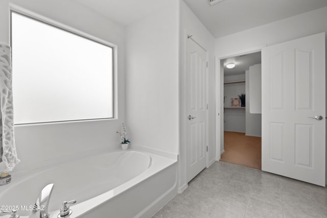 bathroom with a tub and tile patterned floors