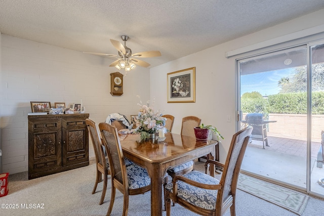 carpeted dining area featuring ceiling fan and a textured ceiling