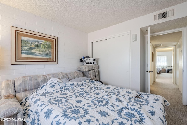 bedroom featuring carpet floors, a closet, and a textured ceiling