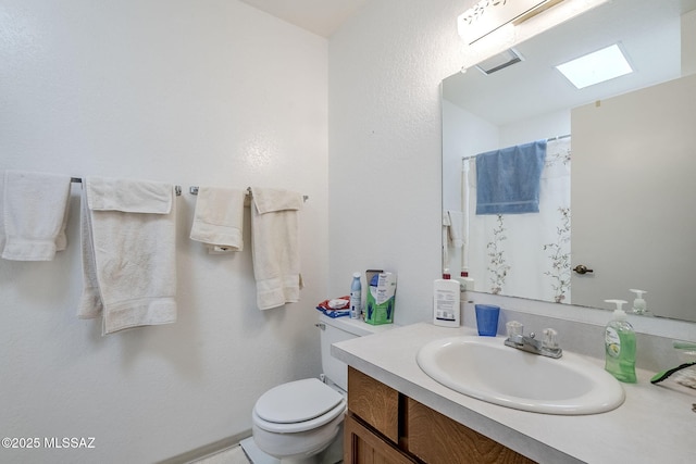 bathroom with walk in shower, vanity, and toilet