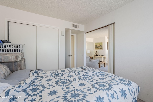 bedroom featuring carpet, a closet, and a textured ceiling