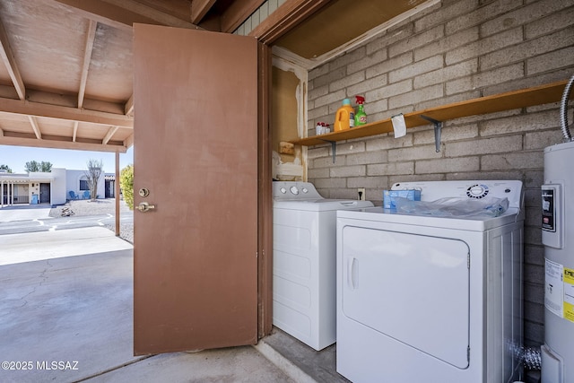 laundry area with electric water heater and washing machine and dryer