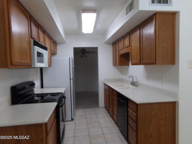 1377 S Desert Meadows Cir, Green Valley, AZ 85614 - kitchen with black appliances, a sink, brown cabinetry, and light countertops