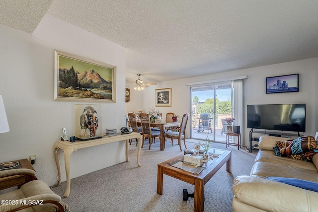 living room featuring ceiling fan, light colored carpet, and a textured ceiling