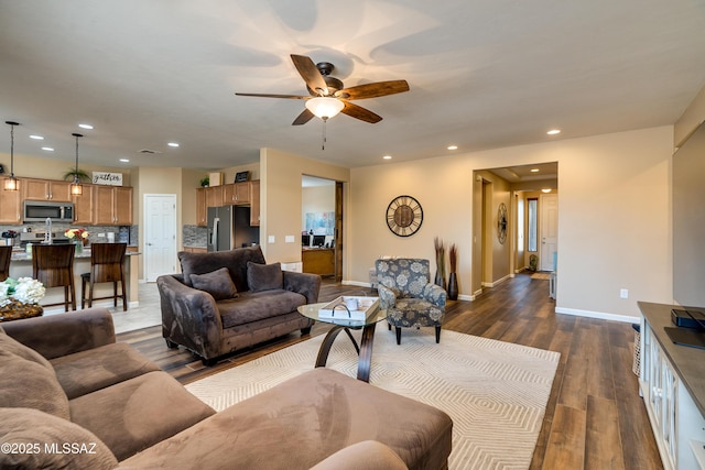 living room featuring ceiling fan and dark hardwood / wood-style floors