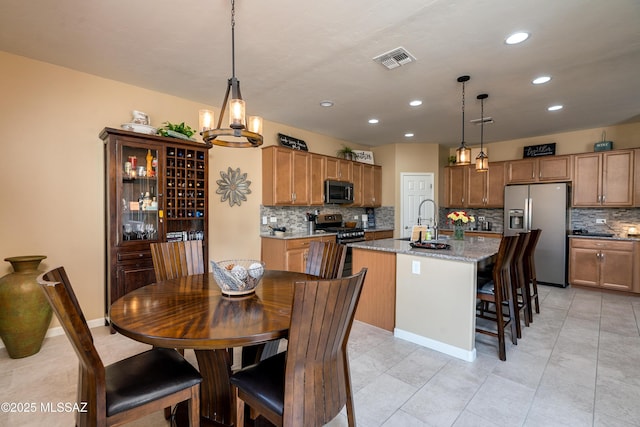 tiled dining room featuring an inviting chandelier and sink