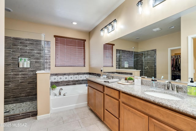 bathroom featuring tile patterned flooring, vanity, and separate shower and tub