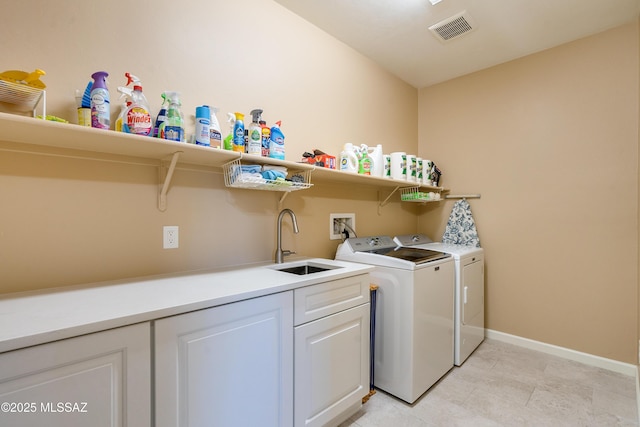 washroom featuring sink, cabinets, and independent washer and dryer