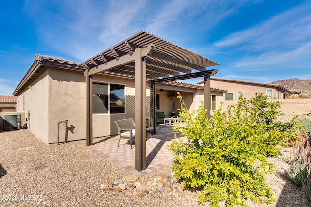 rear view of property featuring central AC unit, a pergola, and a patio area