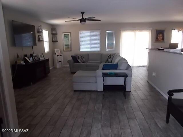 living room featuring dark hardwood / wood-style floors and ceiling fan