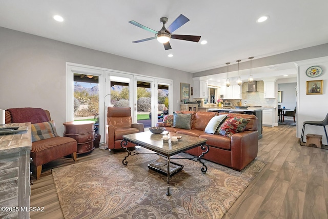 living room featuring ceiling fan, light hardwood / wood-style floors, and french doors