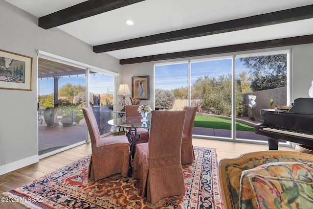 dining area featuring beamed ceiling and hardwood / wood-style floors