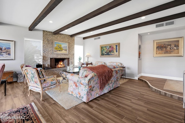 living room featuring hardwood / wood-style flooring, a large fireplace, and beam ceiling