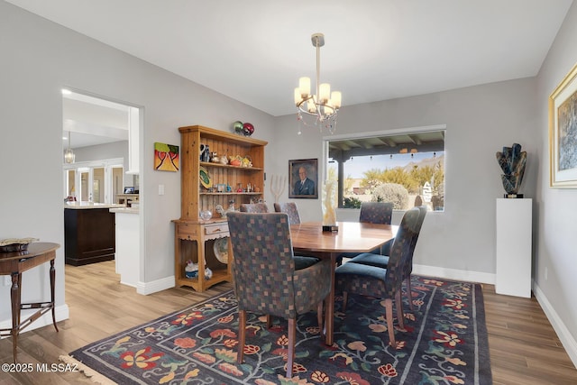 dining room featuring hardwood / wood-style flooring and an inviting chandelier