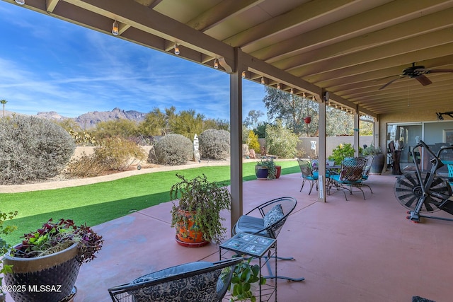 view of patio featuring ceiling fan and a mountain view