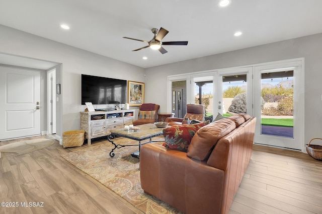 living room featuring french doors, ceiling fan, and light wood-type flooring