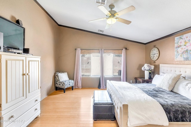 bedroom with ornamental molding, light wood finished floors, vaulted ceiling, and visible vents