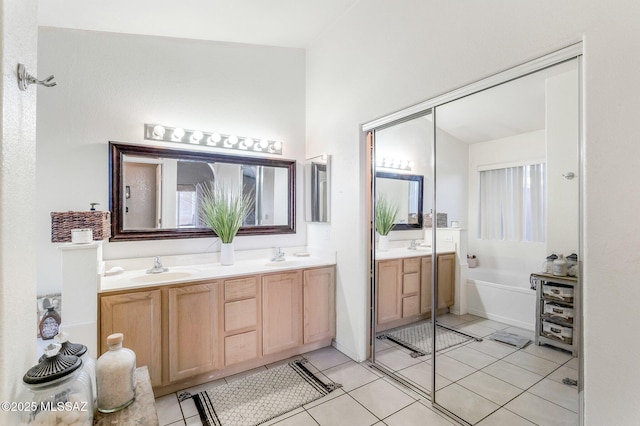 full bathroom featuring a sink, double vanity, tile patterned flooring, and a garden tub