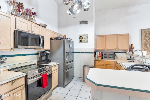 kitchen with visible vents, light brown cabinets, appliances with stainless steel finishes, and light countertops