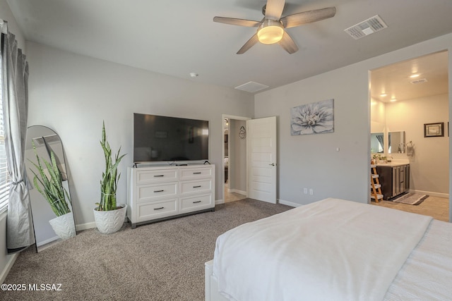 carpeted bedroom with ensuite bath and ceiling fan