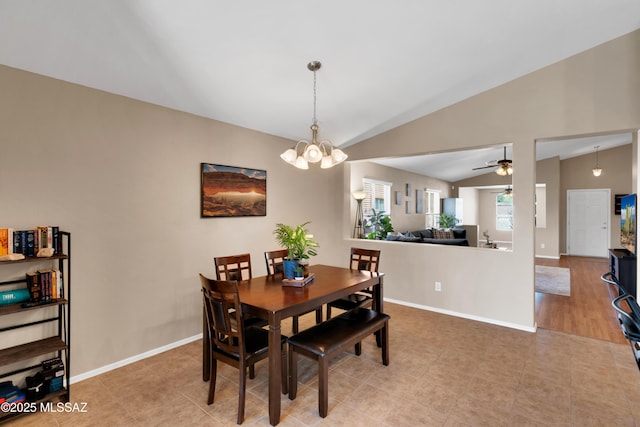 dining room featuring lofted ceiling, light tile patterned floors, baseboards, and a notable chandelier