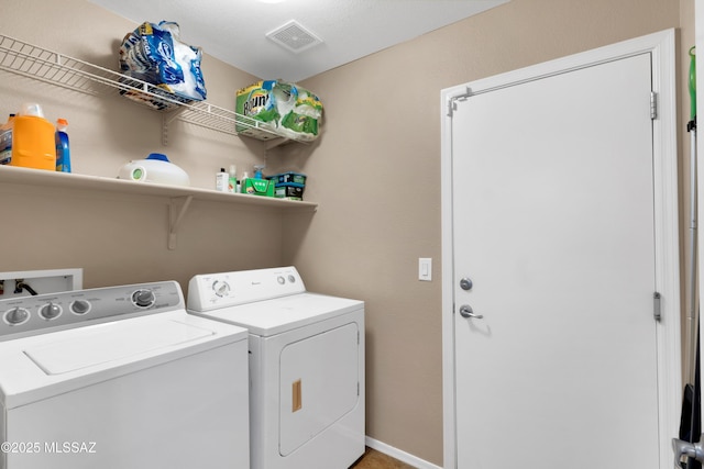 washroom featuring laundry area, separate washer and dryer, visible vents, and baseboards