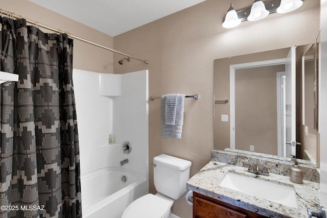 bathroom with a textured wall, vanity, toilet, and shower / bath combo with shower curtain