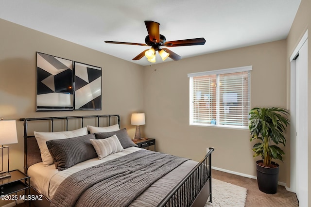 carpeted bedroom with ceiling fan and baseboards