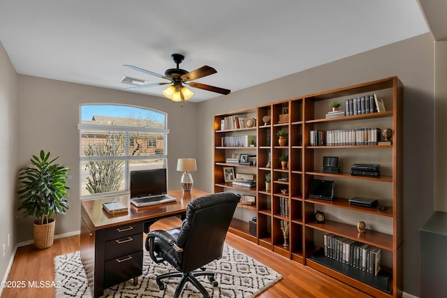 home office featuring baseboards, light wood-style flooring, visible vents, and a ceiling fan