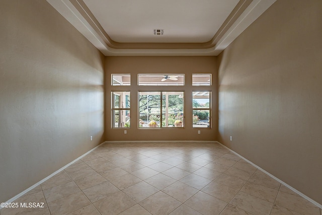 unfurnished room featuring light tile patterned flooring and a tray ceiling