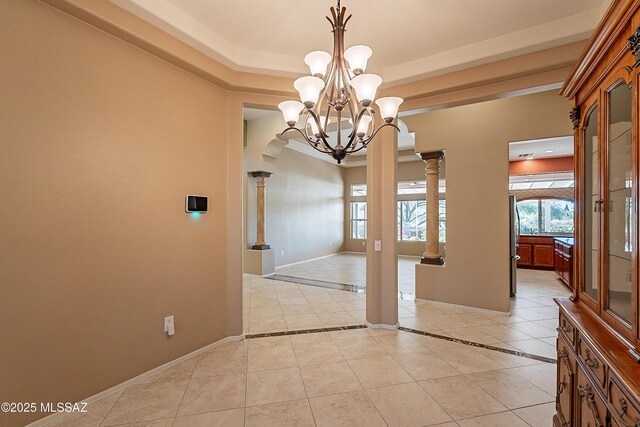 unfurnished dining area with an inviting chandelier, light tile patterned floors, a tray ceiling, and decorative columns