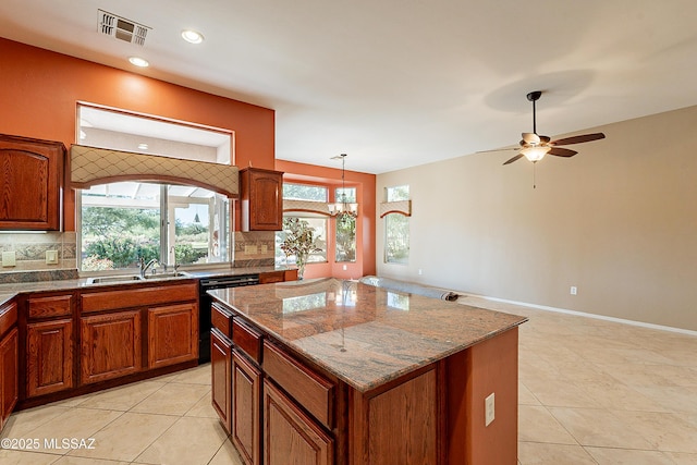 kitchen with hanging light fixtures, decorative backsplash, dishwasher, and a kitchen island