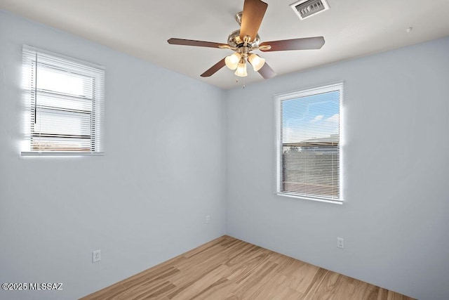 spare room featuring ceiling fan, a healthy amount of sunlight, and light wood-type flooring