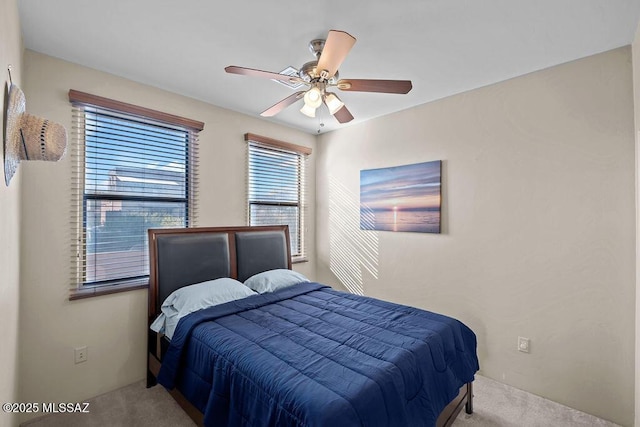 bedroom with ceiling fan and light colored carpet