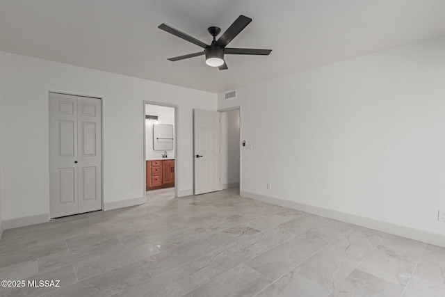 unfurnished bedroom featuring ceiling fan and ensuite bath